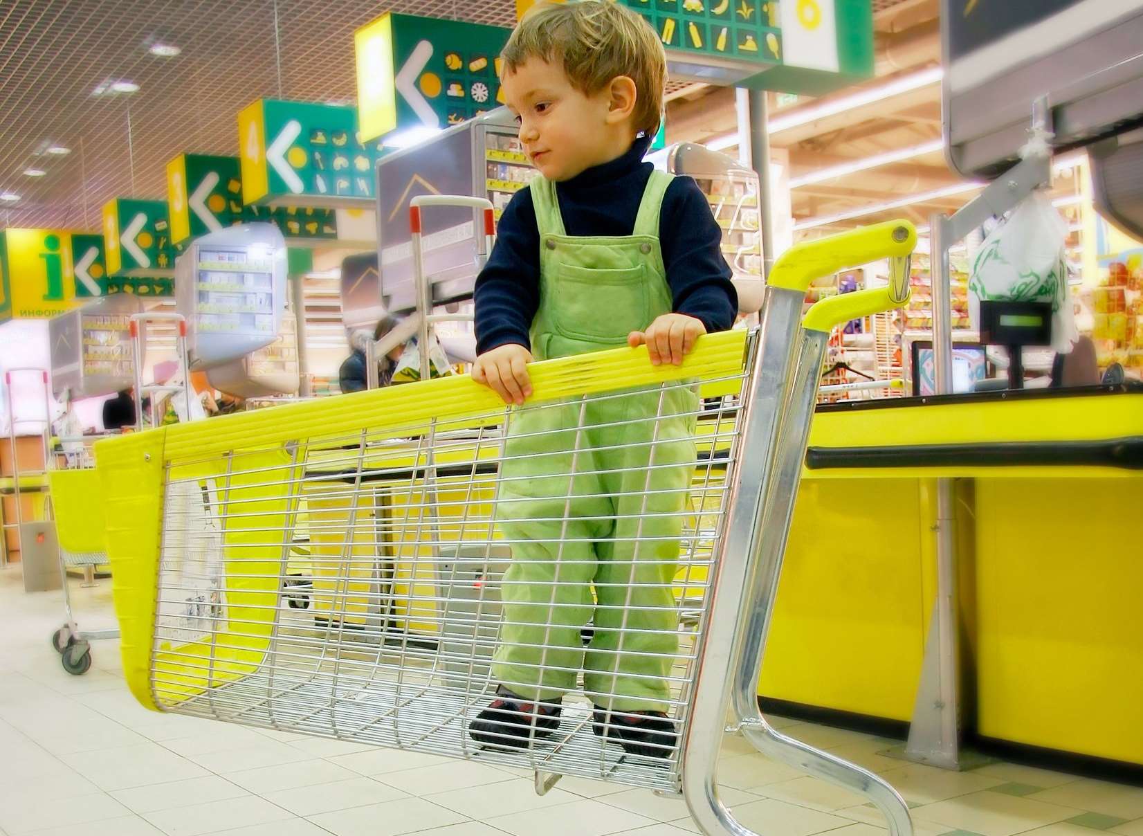 A child standing in a shopping trolley. Picture posed by model