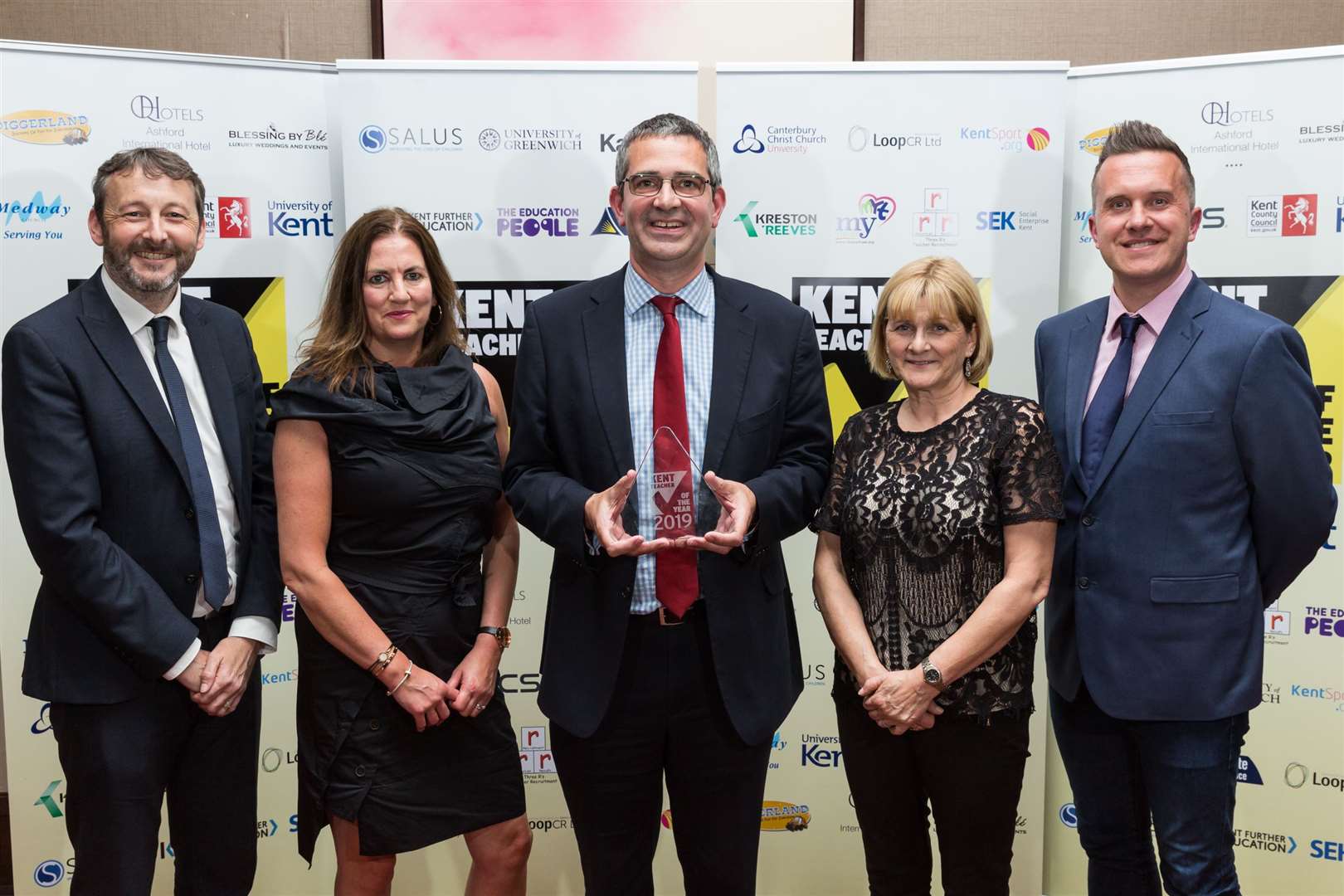Pete Talbot, Sarah Merritt and Sue Parsons from Castle Hill Community Primary School collect the overall Kent Senior Leadership Team of the Year Award. Presented by James Robert from The Education People and Phil Gallagher, presenter of CBeebies Mister Maker and patron of the KM Charity Team.