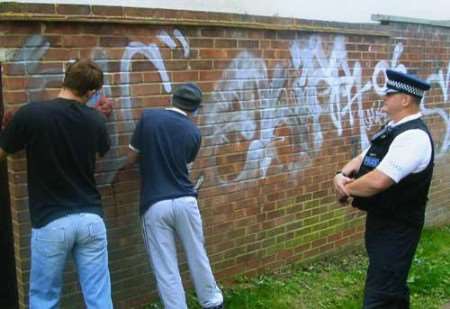 PC Kevin O'Rourke supervises the boys as they clean up their graffiti
