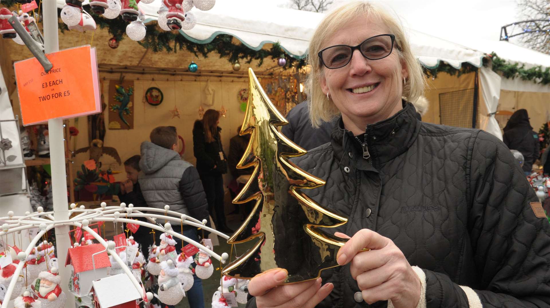 Elaine Man picks up a mini tree last year at Rochester festive market Picture: Steve Crispe