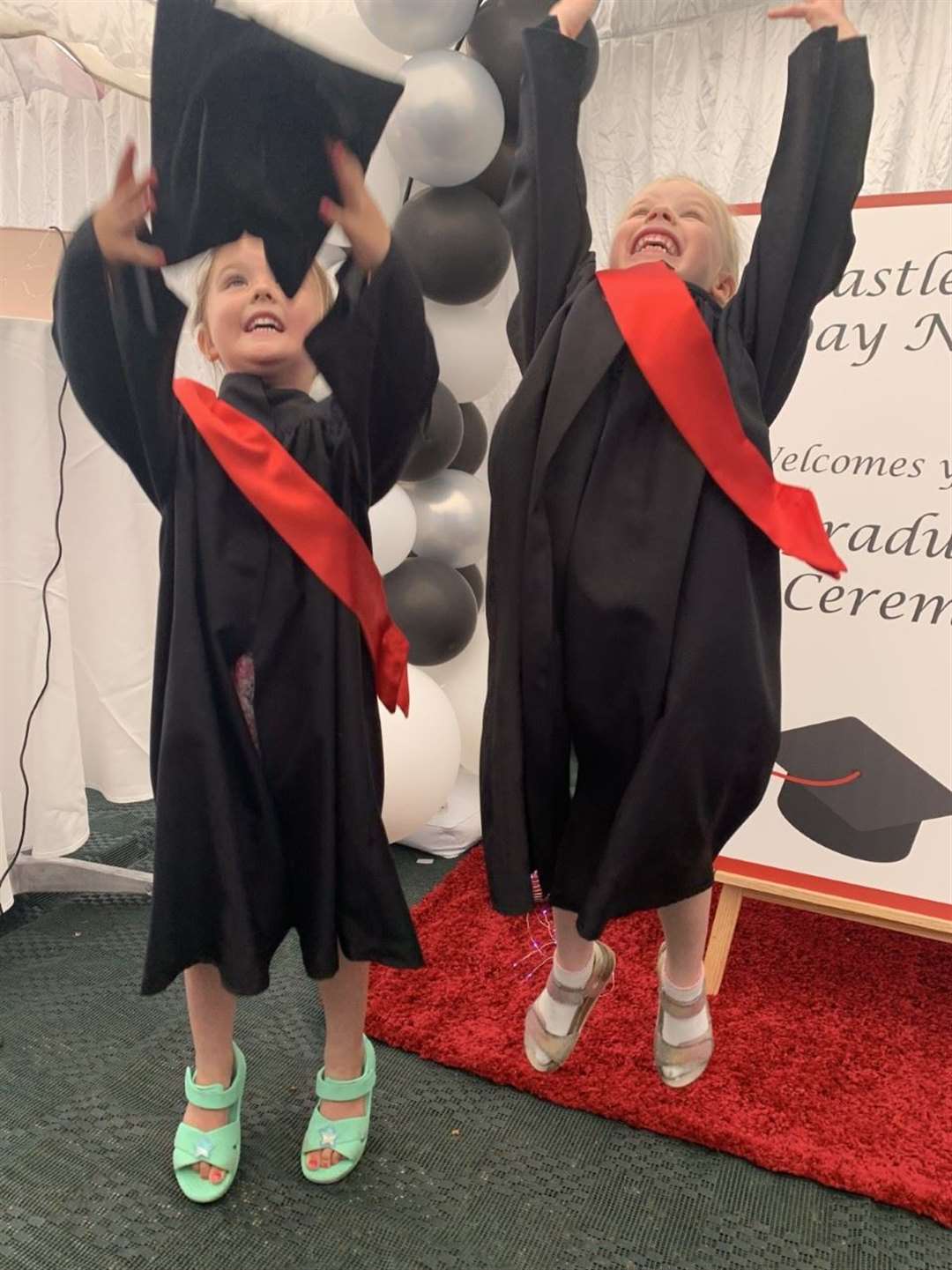 Marlowe and Poppy throwing their graduation caps