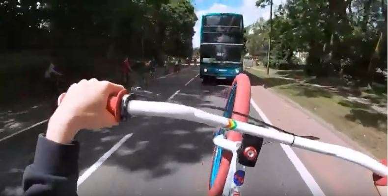 A point of view video shows one rider cycling straight towards a bus