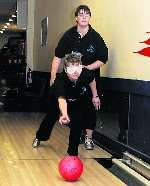 Paula Gunnell bowls blind folded with the help of Christine Hewitt