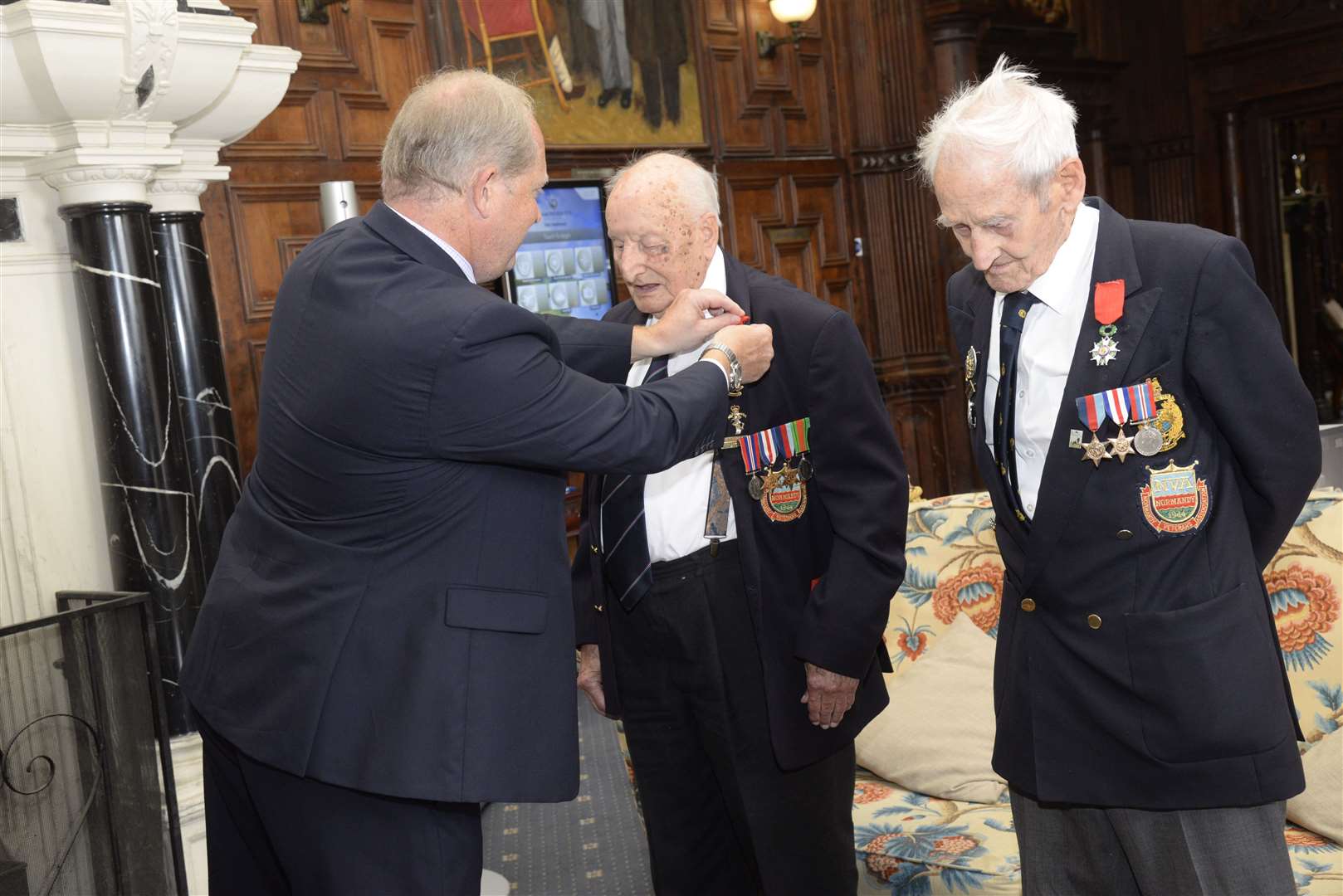 Honorary French Consul James Ryeland presenting medals to D-Day veterans Frank Suttie and Frank Gibbins at the Legion D'Honneur presentation in 2016