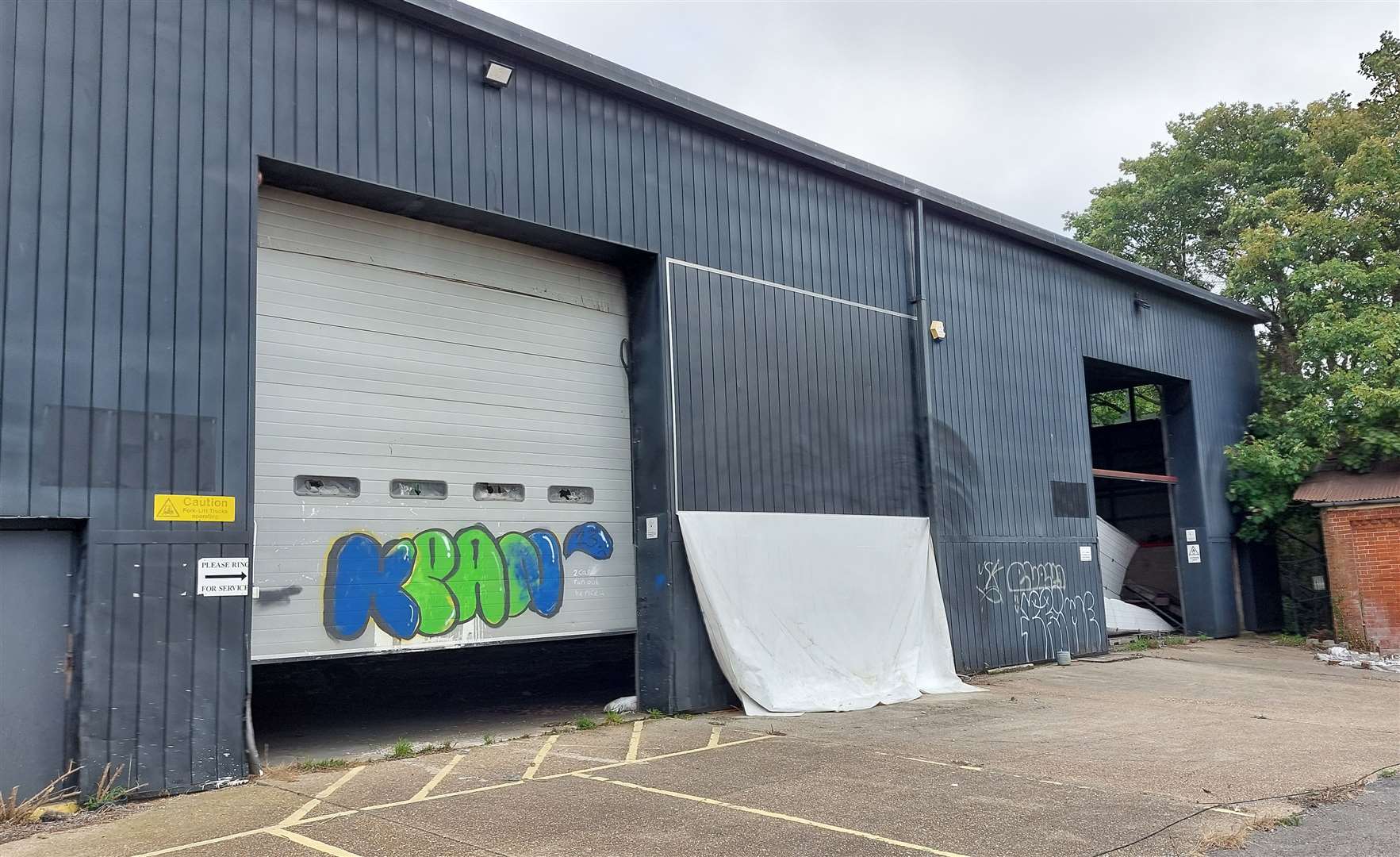 Graffiti tags have been sprayed on the disused buildings