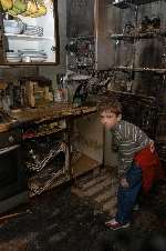 Jake Ling, 7, in the damaged kitchen. Picture: BARRY DUFFIELD