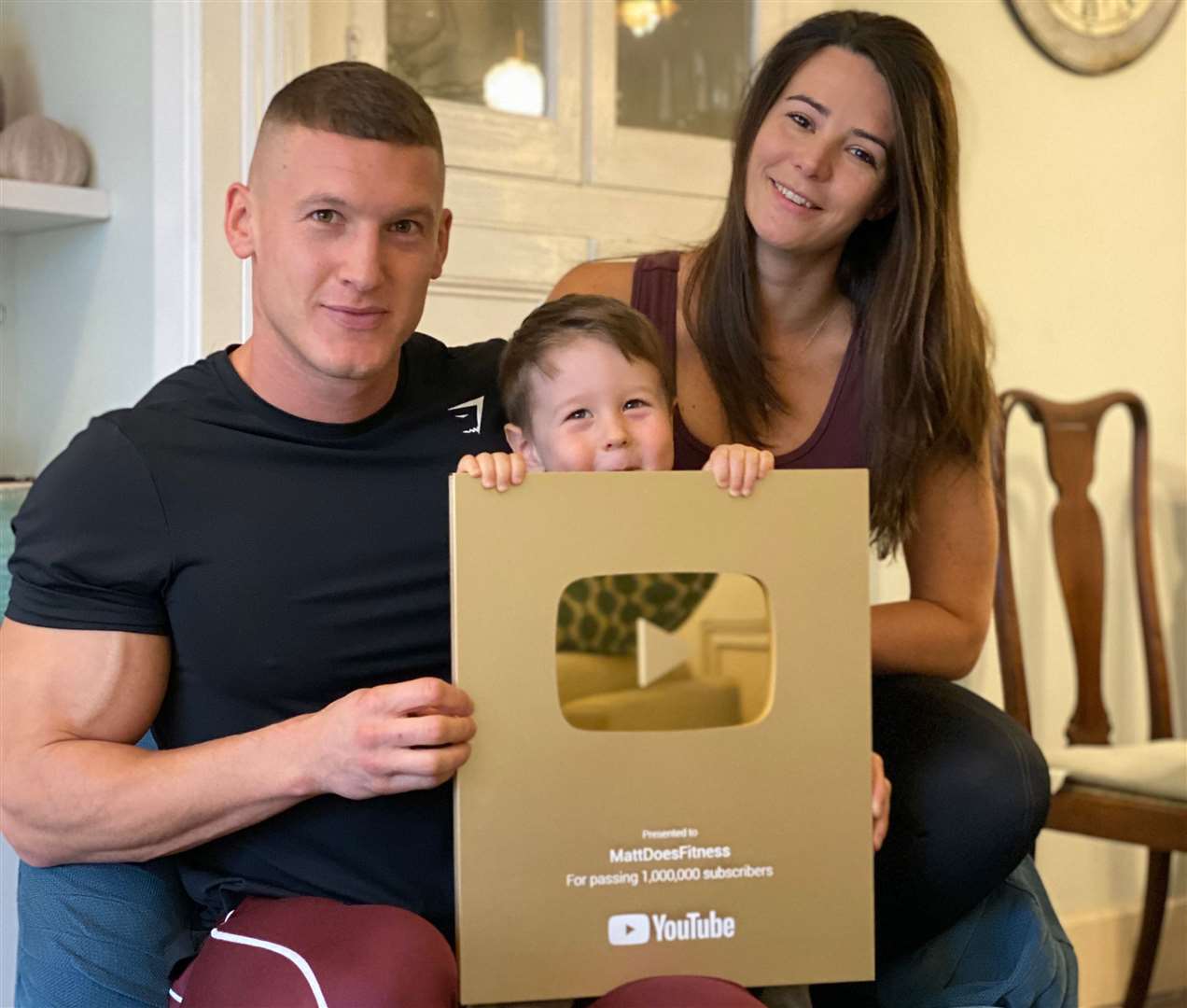 Matt, Sarah and three-year-old Luca with a YouTube Creator Award for gaining a million subscribers to the MattDoesFitness channel
