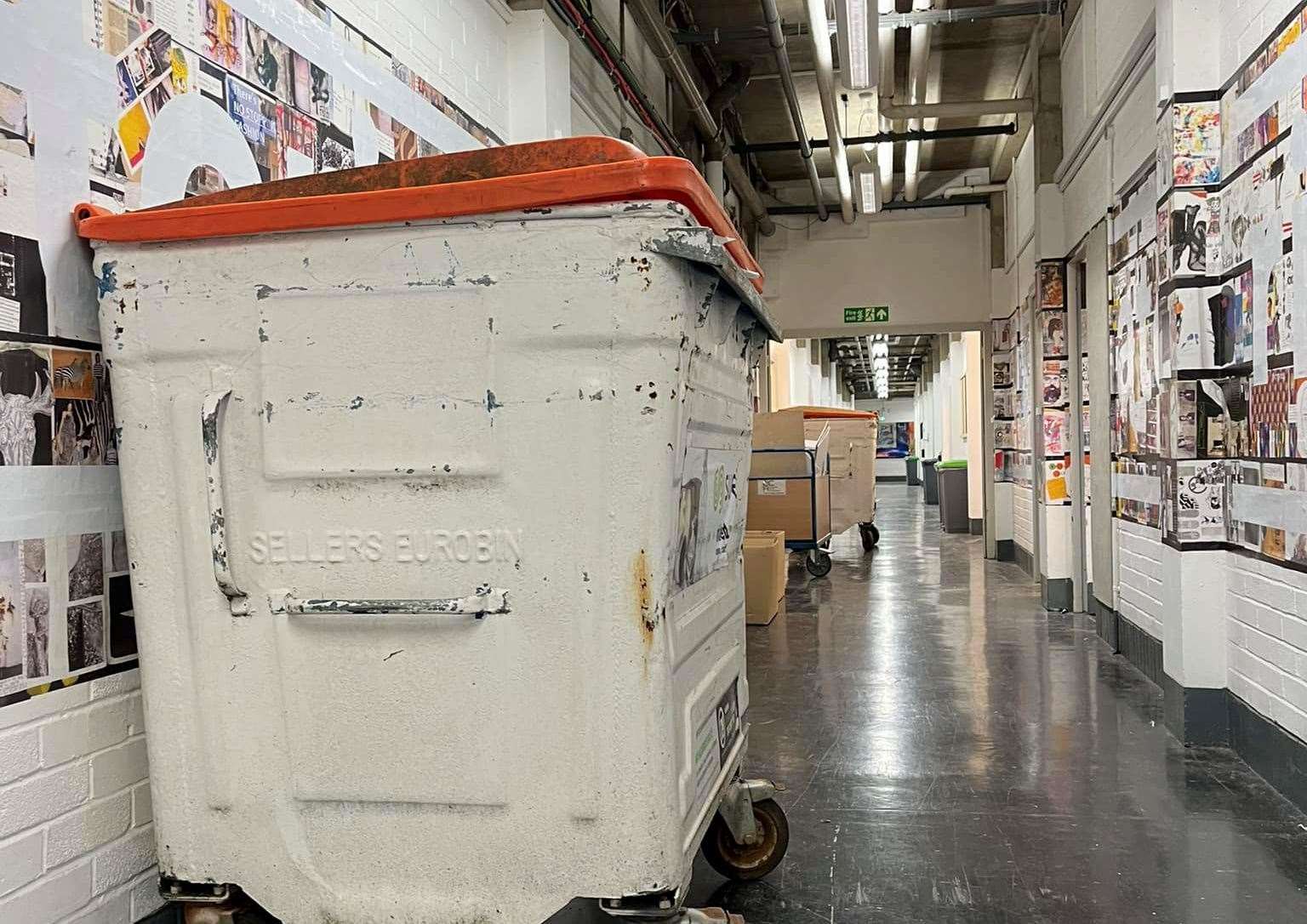 Large skips in the corridors of a once busy arts college