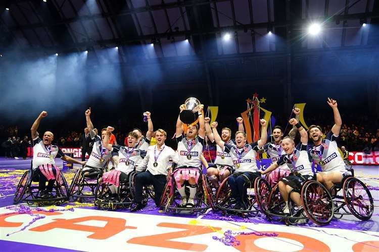 England’s Tom Halliwell lifts the trophy with team-mates after victory in the Wheelchair Rugby League World Cup final match at Manchester Central (PA)