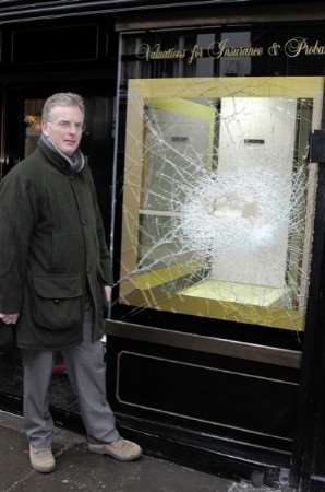 Anthony Pearce beside one of the damaged windows. Picture: Paul Amos