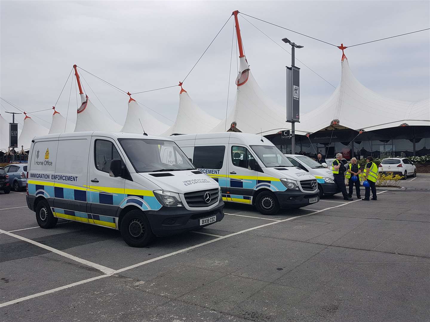 Three Home Office vehicles are currently stationed in the Ashford Designer Outlet car park