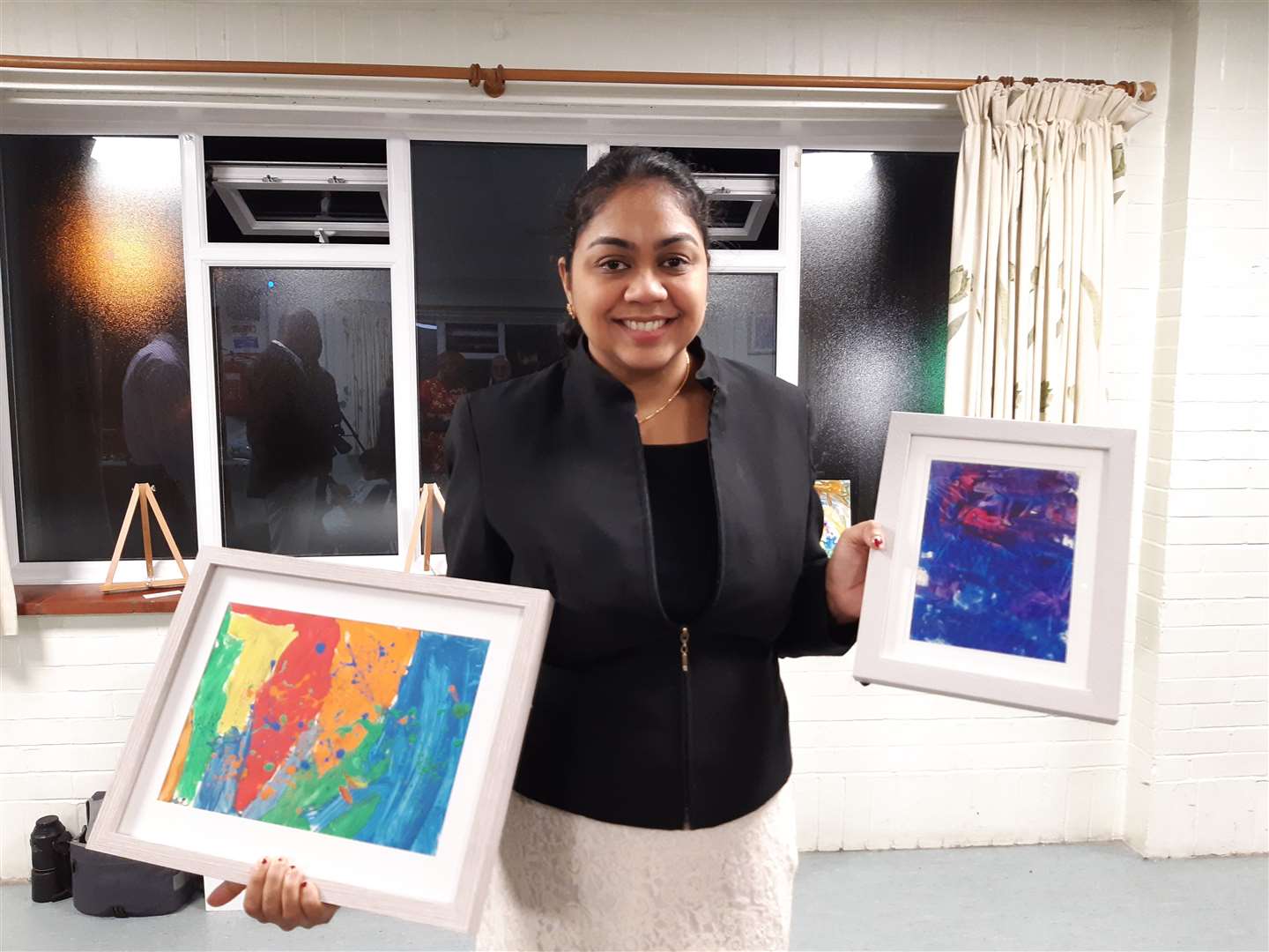 Divya Nagarajan holding her daughter's paintings