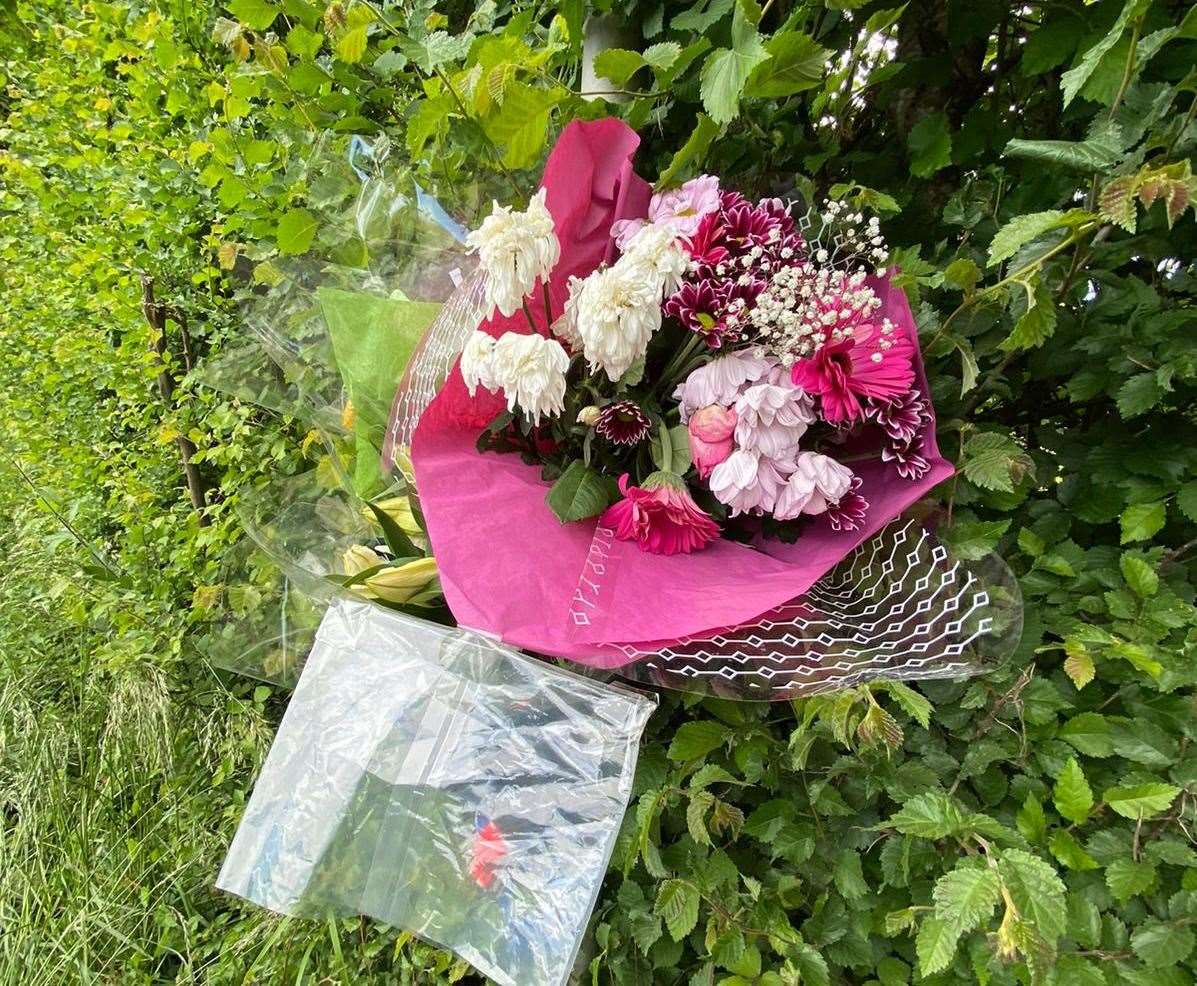 Floral tributes and a card were left tied to a post. Photo: Barry Goodwin