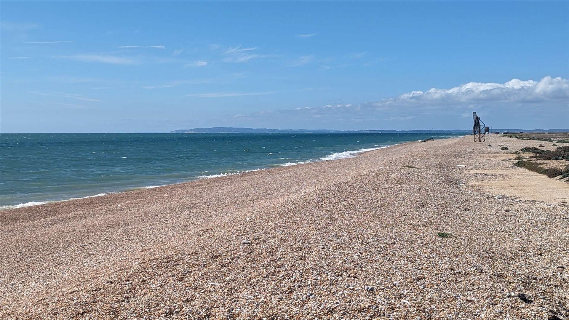 The deserted beach with the Sussex coast lying across the sea