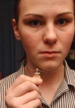 Samantha Devine with the crucifix and chain she was told to remove. Picture: BARRY CRAYFORD