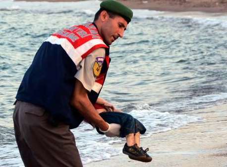 A Turkish rescuer carries Aylan's body