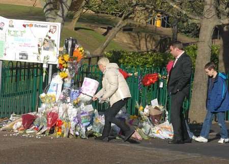 Hayden's mother and father Hayley and Gary, and his brother Aaron, view the floral tributes. Picture: VERNON STRATFORD