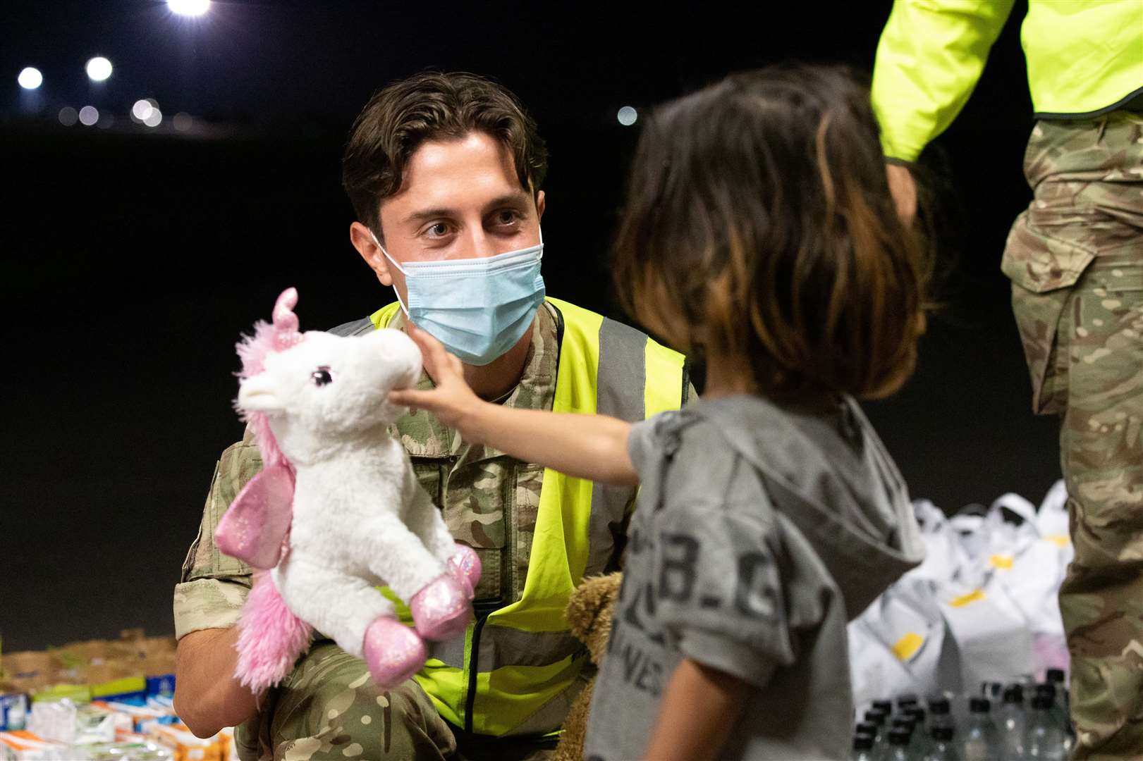 A member of RAF Brize Norton personnel handing out a toy to a child refugee last Thursday. Picture: UK MOD