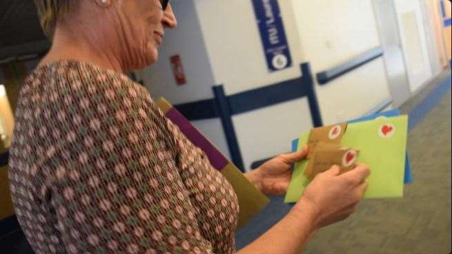 A member of staff distributes letters to patients from family members