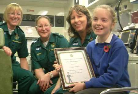 PRAISE: Abby with her special certificate and members of the ambulance service