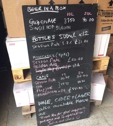 A blackboard displays the various beers, wines, lagers and ciders on offer for takeaway or delivery
