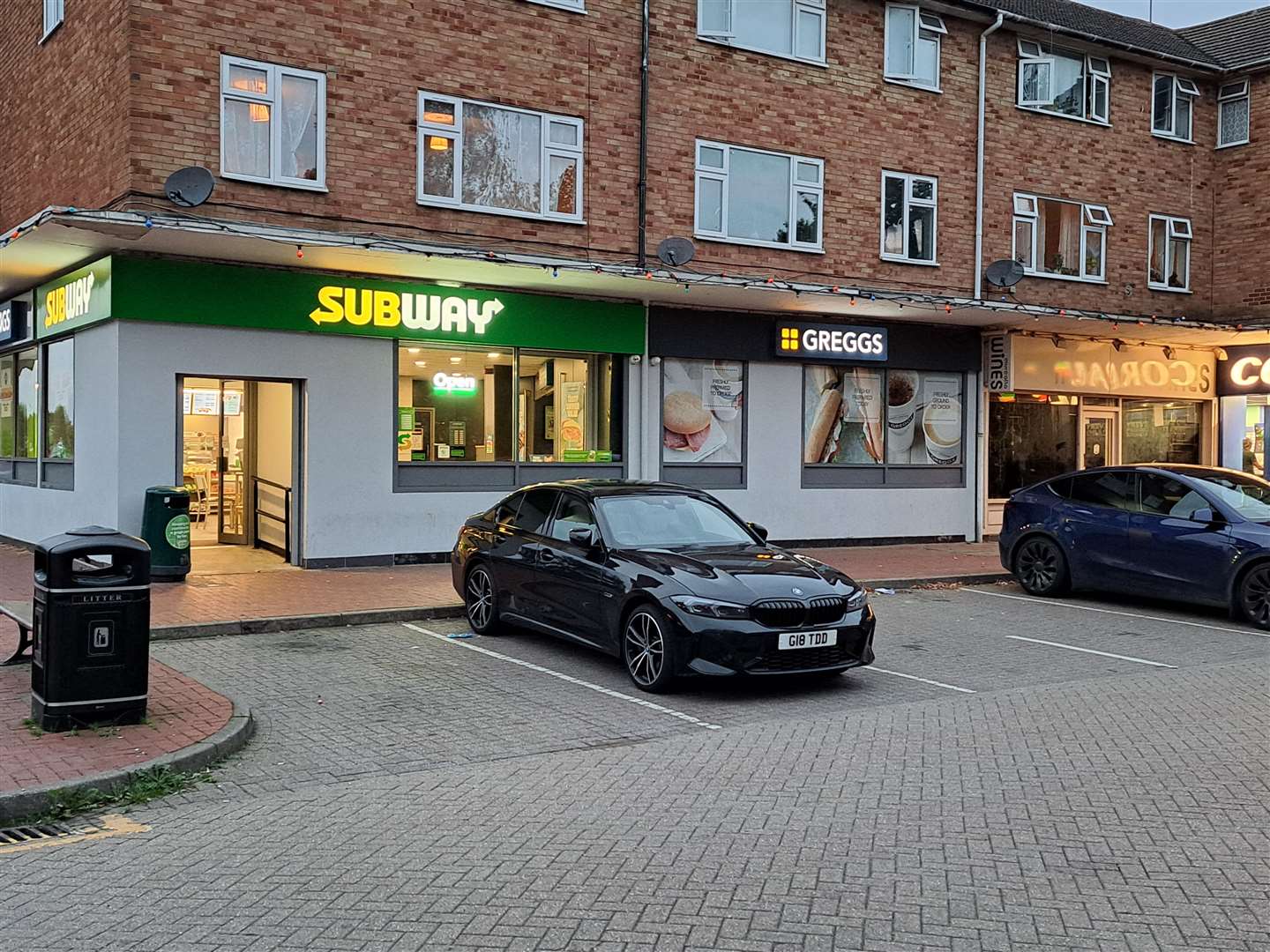 It is adjacent to a Subway and a Greggs