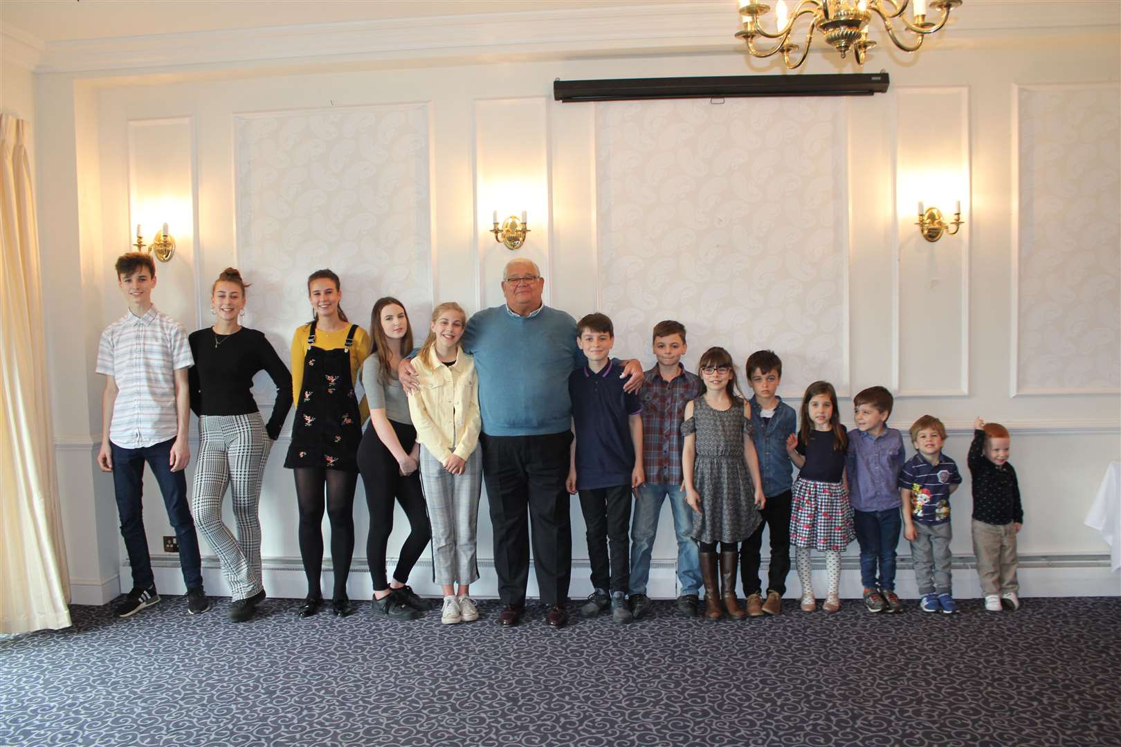 Reg Belcourt with his grandchildren. From left to right: Louis, Sophie, Jessica, Lily, Maddy, Reg, Archie, George, Ava, Elliot, Betsy, Edward, Frank and Rupert