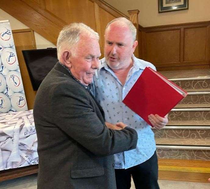 Danny Ward presents Jim with his red folder of memories.
