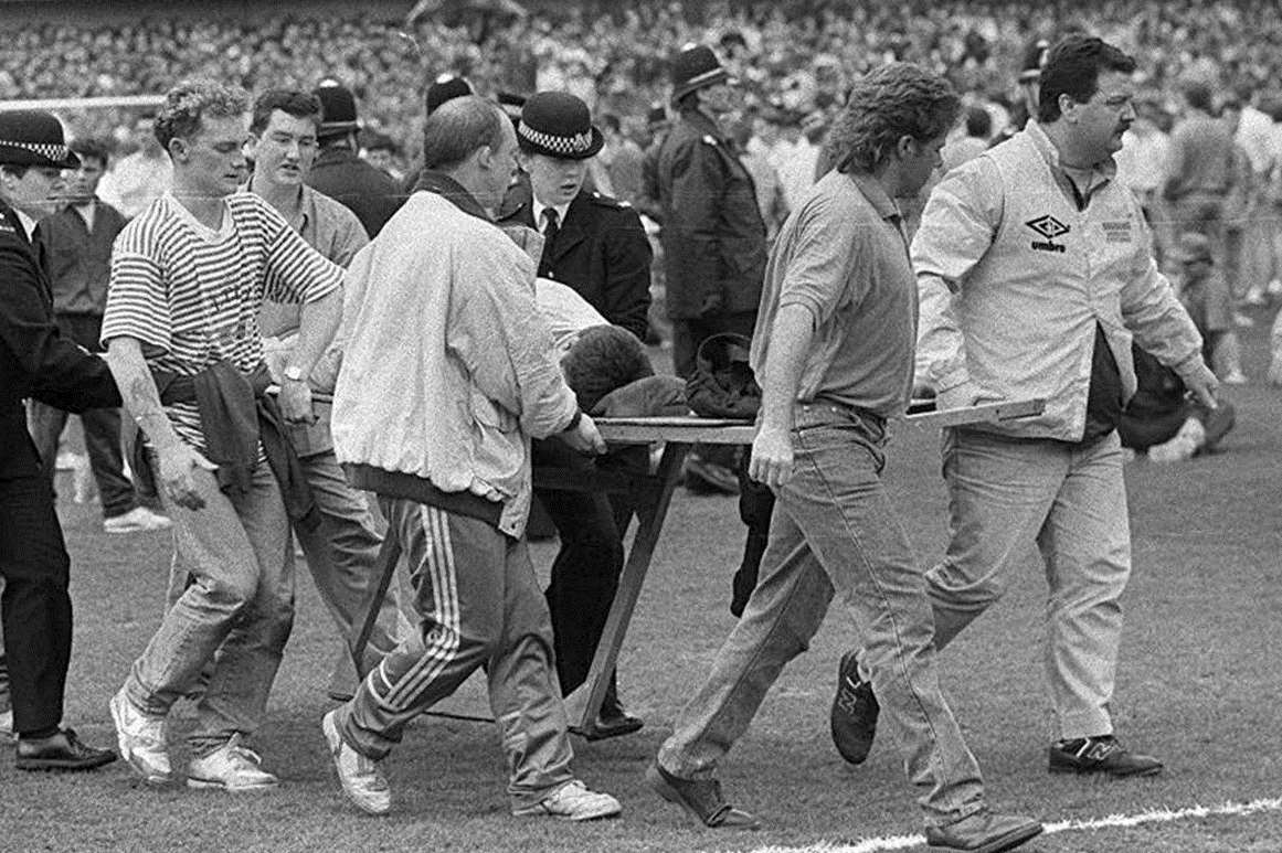 Injured fans are carried on stretchers during the Hillsborough disaster on April 15, 1989. Picture: Ross Parry/Sheffield Star