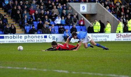 Cody McDonald is fouled by Shrewsbury captain Ian Sharps who was sent off in the dying minutes