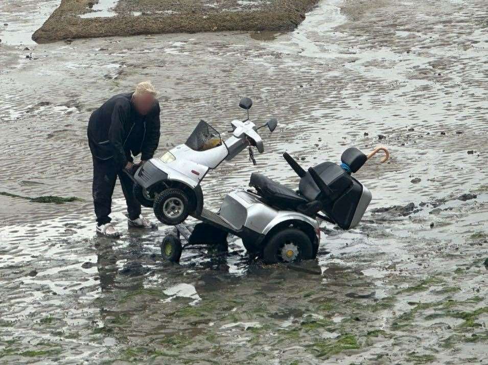 A man struggles with a mobility scooter after getting stuck in Folkestone harbour. Image: Sandy’s fish and chips