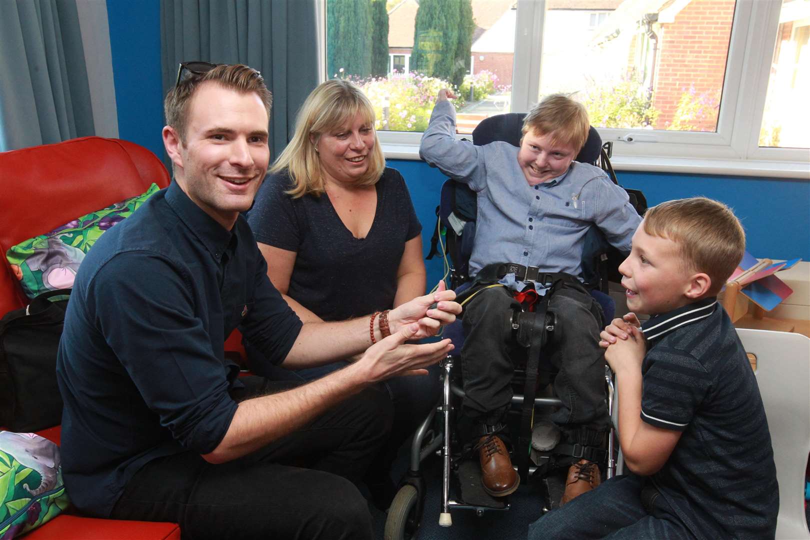 From left, Richard Jones winner of Britain's Got Talent, a couple of years ago, shows Carla Iles and her two sons, James Iles, 14 and Max Phillip, seven, a magic trick during the show for children and family at Demelza Hospice Care for Children. Picture by: John Westhrop (5050877)