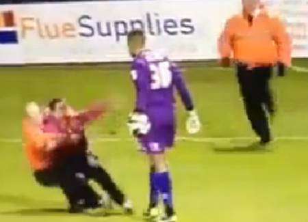 The Gills fan is wrestled to the ground after leaping on Wycombe keeper Jordan Archer