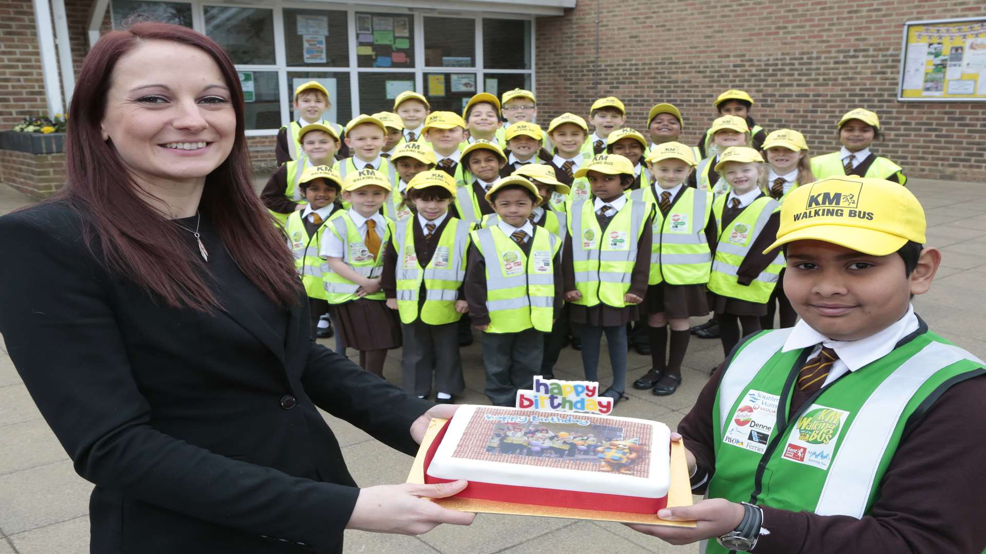 Amy Woods of Three R's Teacher Recruitment with Reuben Kurian and other pupils from St Francis Catholic Primary School celebrating the 4th birthday of their walking bus.