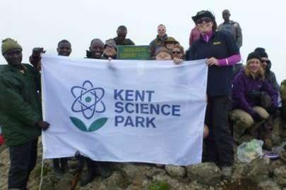 Debbie Cameron flying the Kent Science Park flag at the top of Mount Elgon