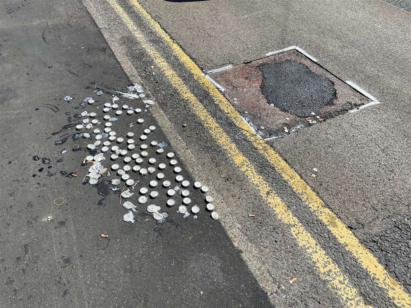 Candles were left by a recently-patched pothole close to the tributes