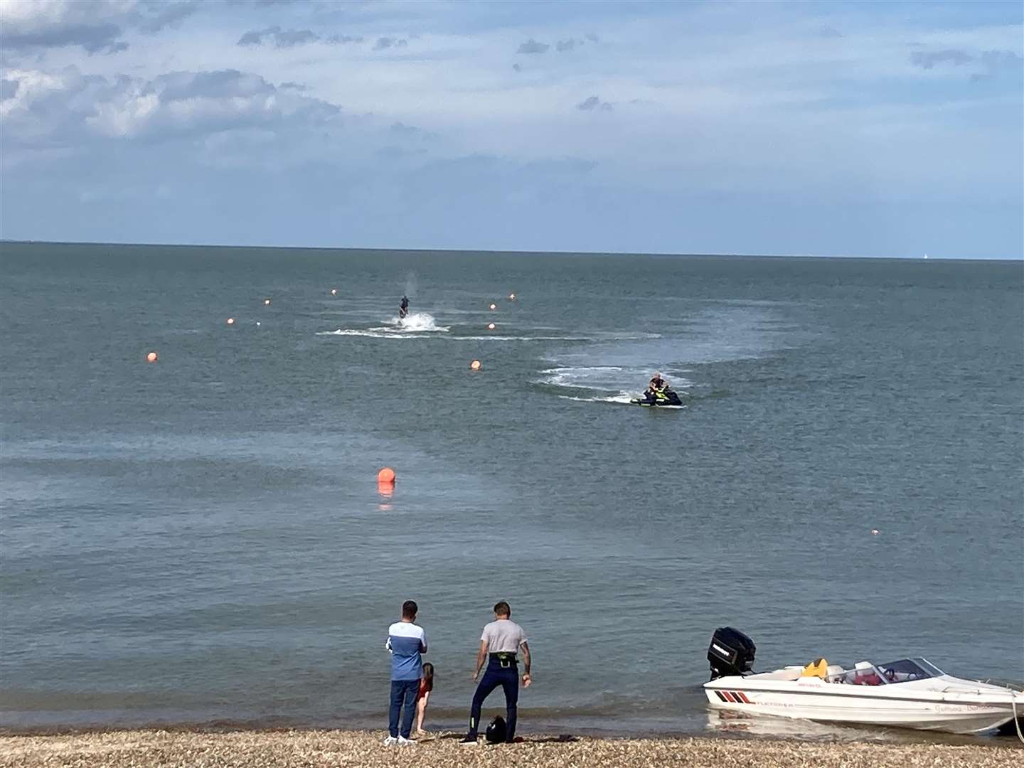 Jet-skiers appeared oblivious to the sunken car at the shingle bank on Minster beach, Sheppey, this afternoon