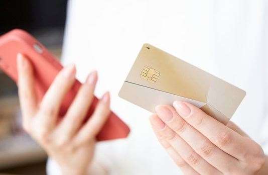 Person holding bank card and phone