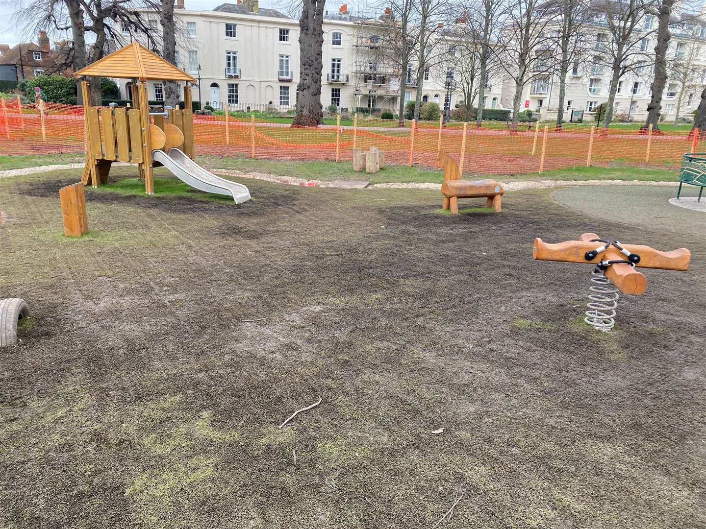 The area features a range of play equipment including swings, a seesaw, a roundabout and slide, all open to use by children up to seven years in age