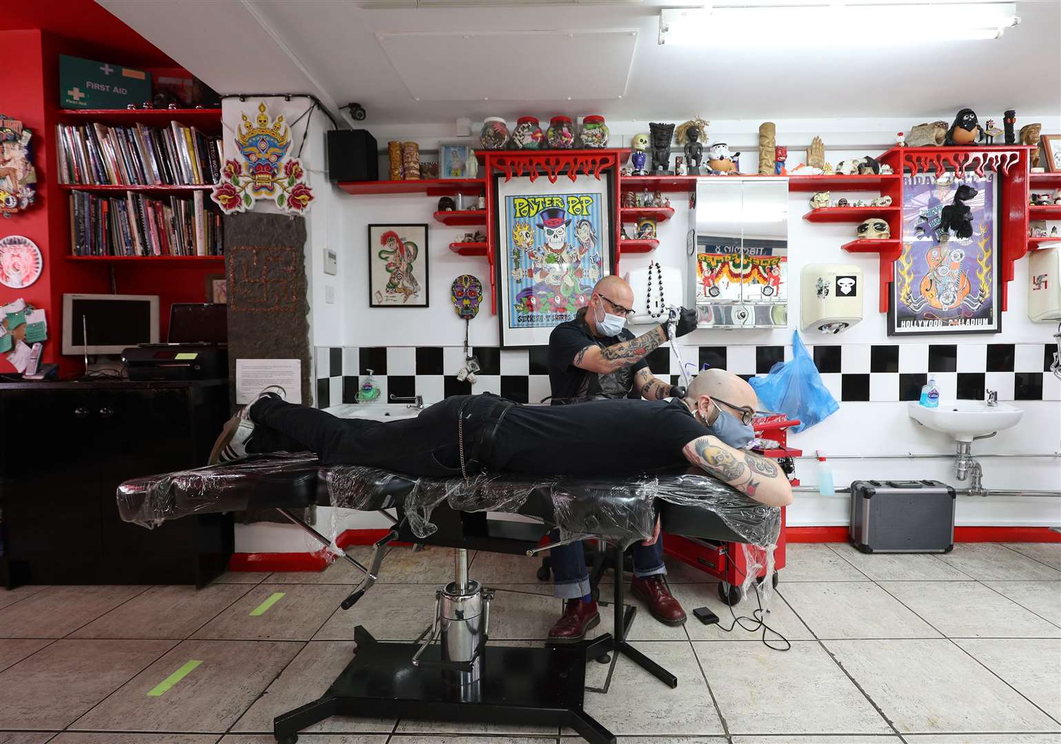 Tattoo artist Dale Frame gives his colleague Boris Di Prospero a swallow tattoo at Flamin’ Eight tattoo studio in Kentish Town, London (Yui Mok/PA)