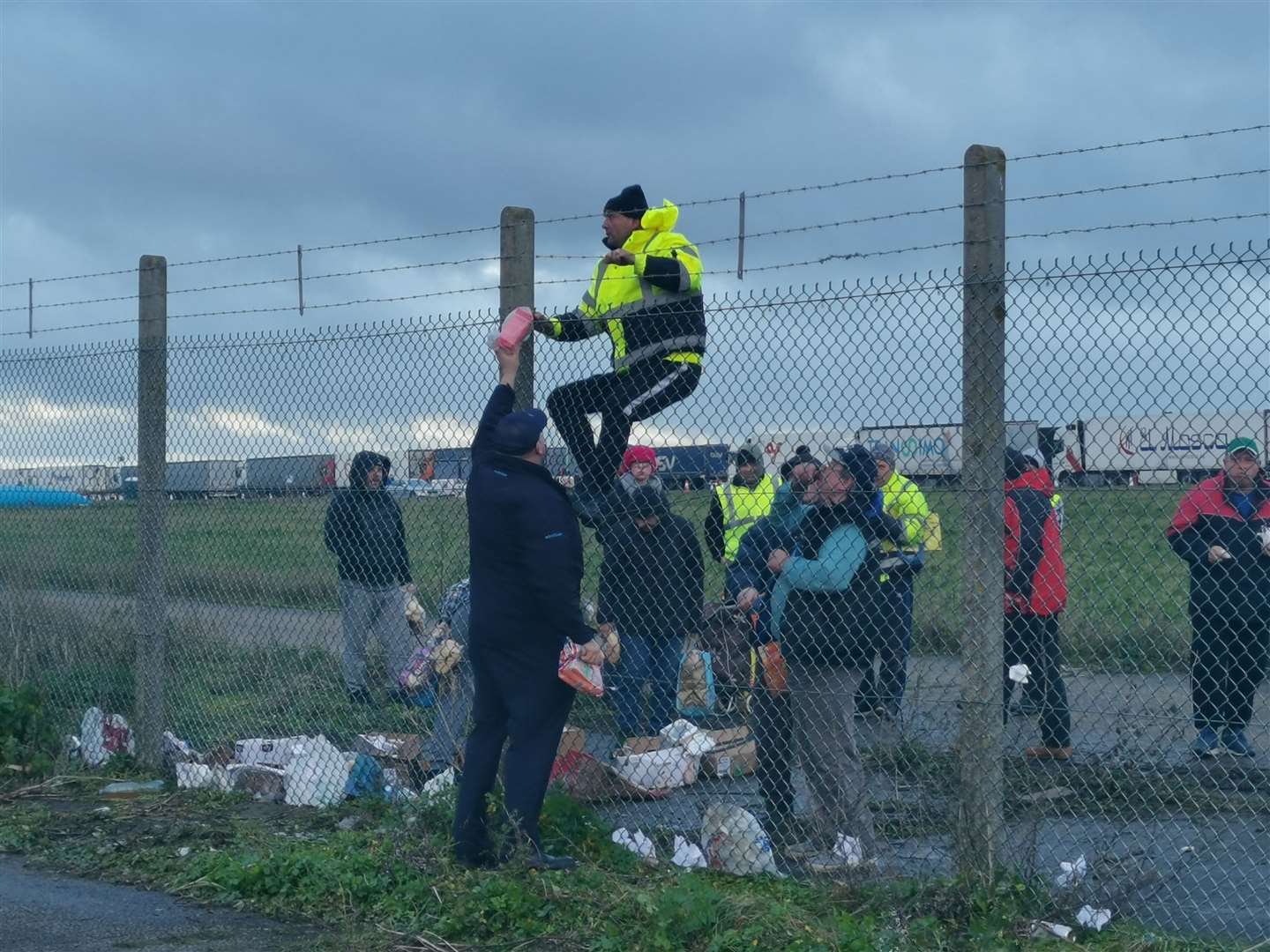 Lorry drivers receive food which is passed over the fence at Manston Airport
