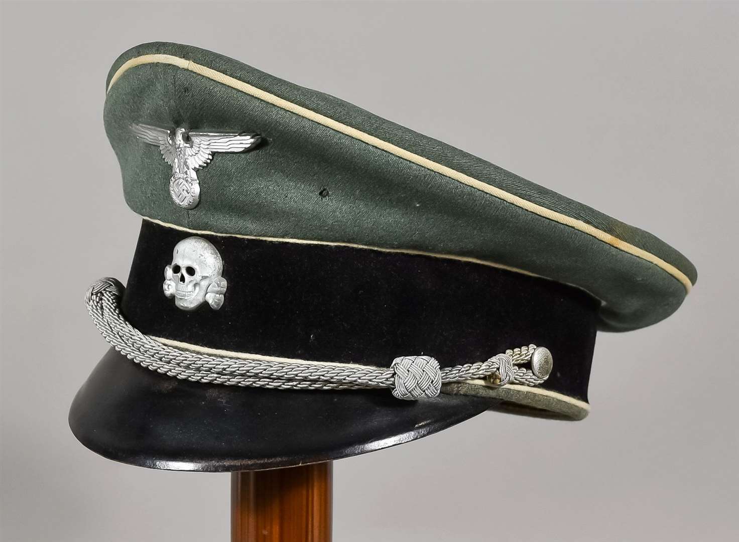A German WWII Cap, field grey with eagle over swastika badge and deathshead badge