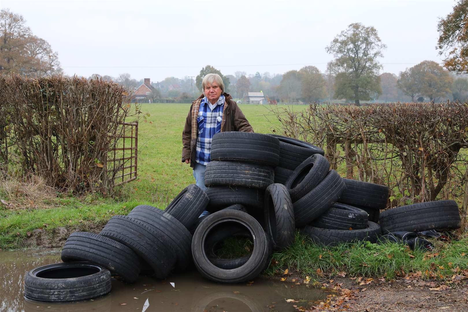 Pictured is Lester Gosbee next to fly-tipped tyres in Staplehurst Road, Frittenden