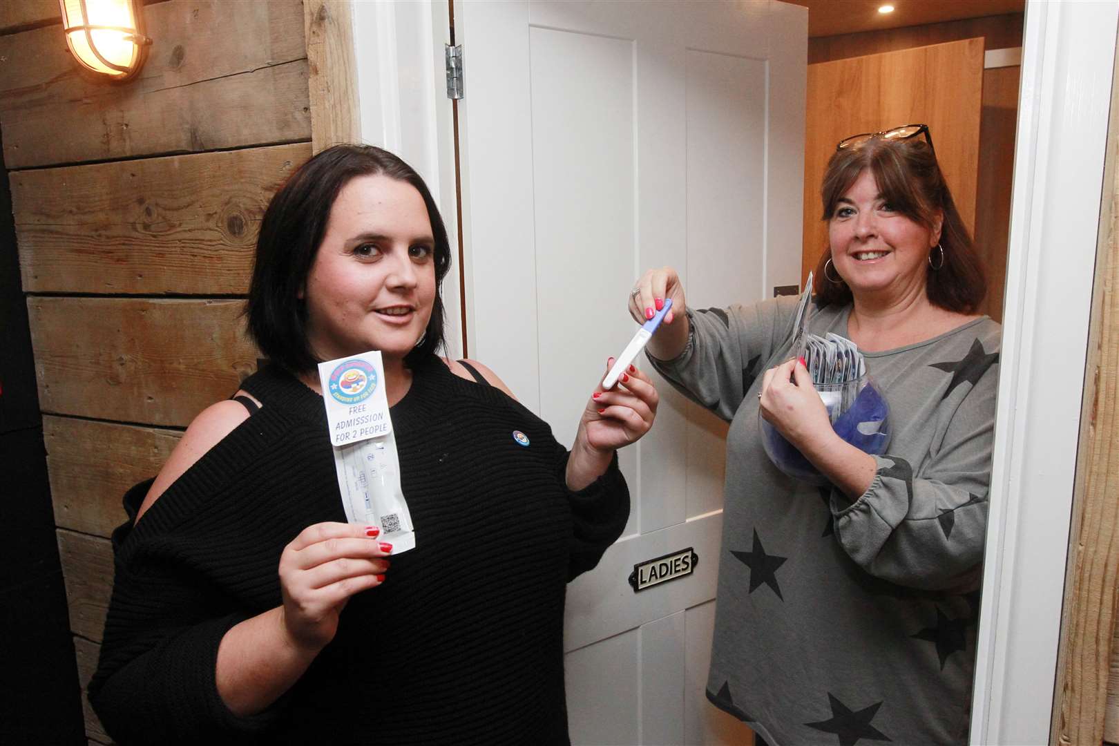 From left, Sara Frost, volunteer and Sharon Jackson, Organiser, outside the toilets in the Moondance Bar Rochester promoting pregnancy testing kits at the launch of their free pregnancy testing campaign. Picture: John Westhrop.. (16329539)