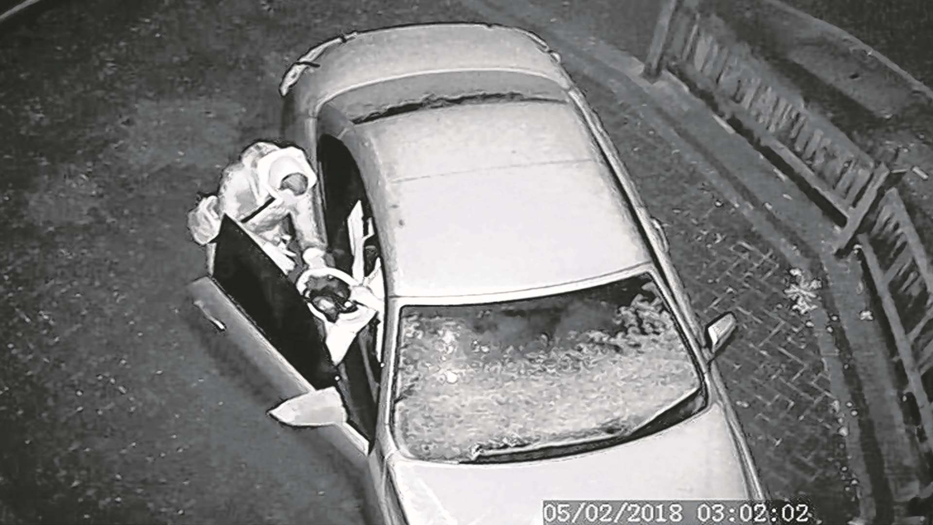 The thief can be seen handing over the steering wheel and other items from inside the car.