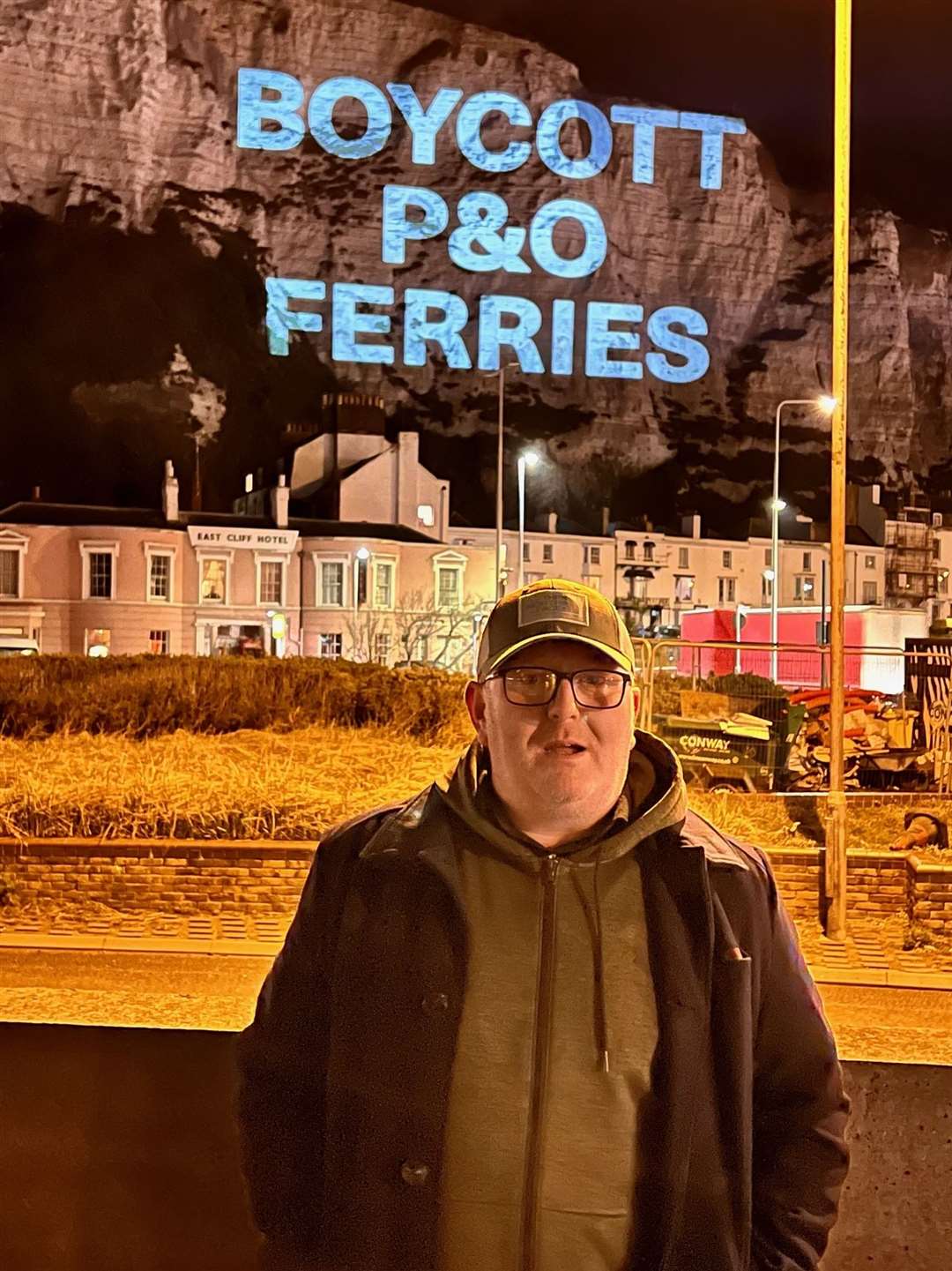 RMT national secretary Darren Procter with the projection on the cliffs. Picture: Nautilus, RMT, ITF