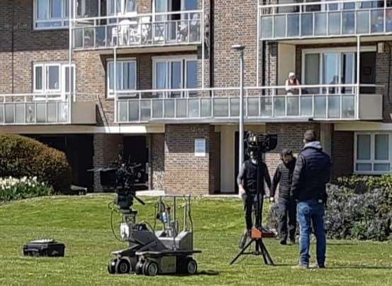 Camera crews set up for the filming of Pistols watched by residents in the Gateway Flats