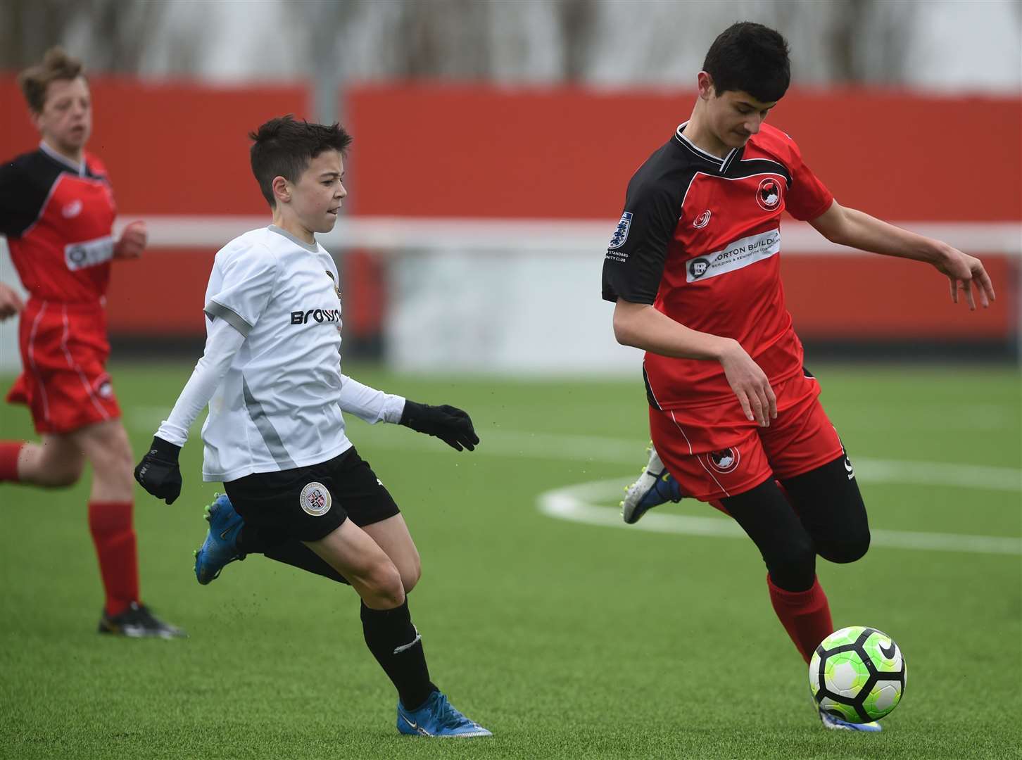 Phoenix Sports (red) under-13s bring the ball out of defence. Picture: PSP Images