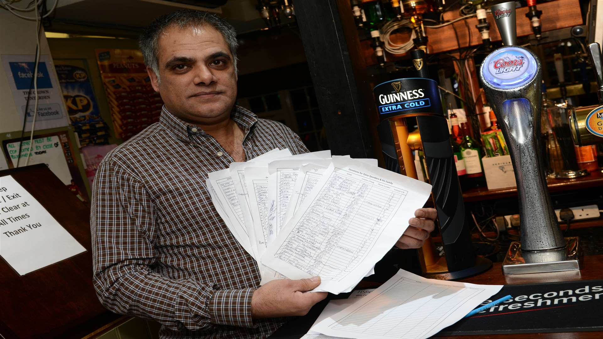 Landlord of The Crown pub, Harry Purewal with some of the pledges of money raised for Dazy Saunders