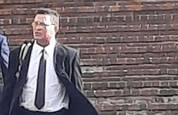Charles Wood, in black suit and glasses, leaves court